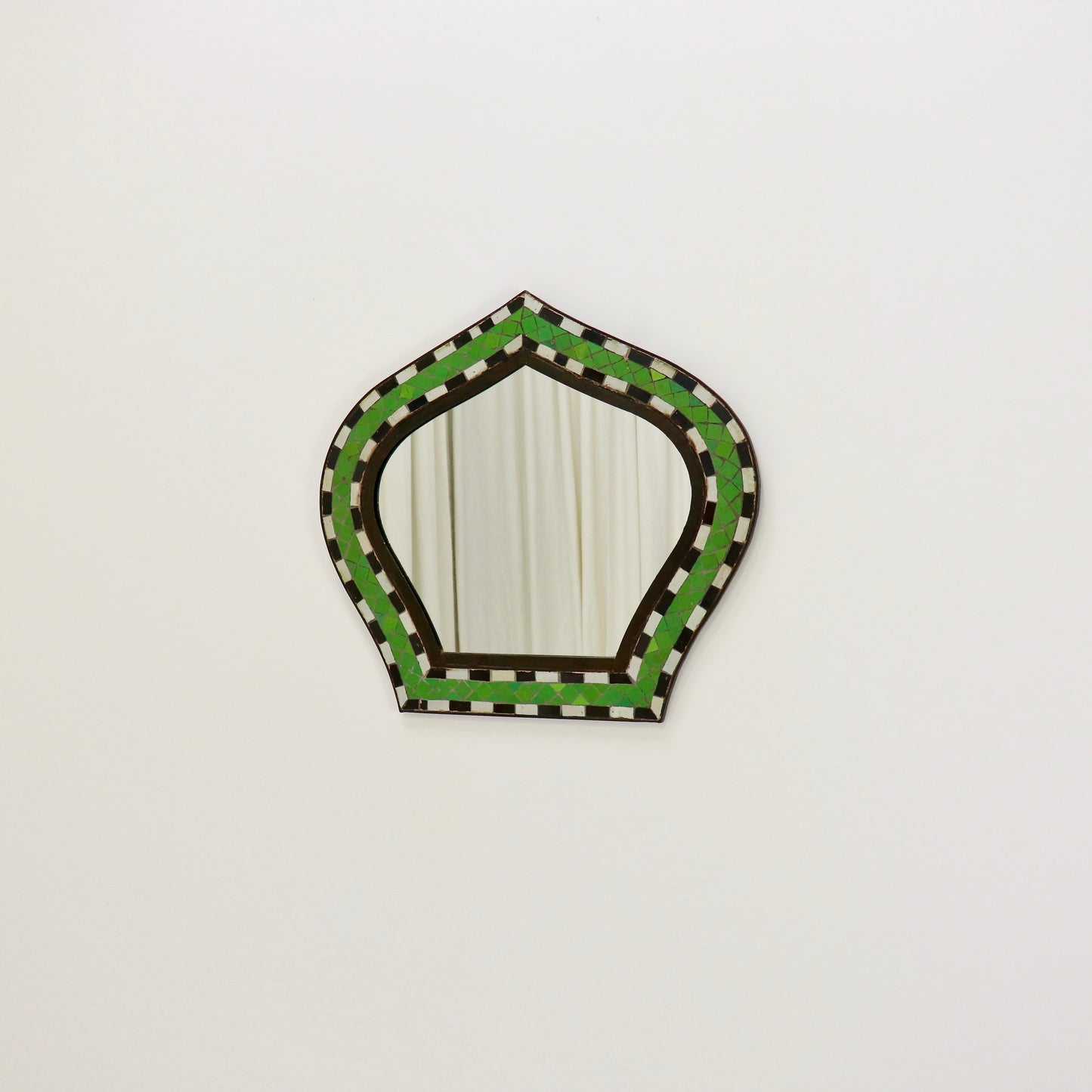 Mosaic mirror reflecting neutral interior backdrop