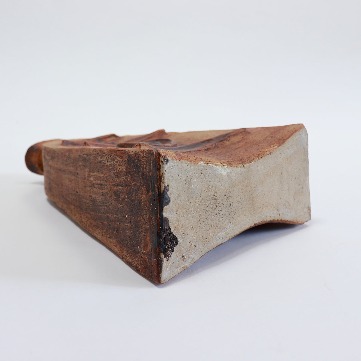 Underside of the Cornish pottery vessel showing its pale exposed clay base and angular body.