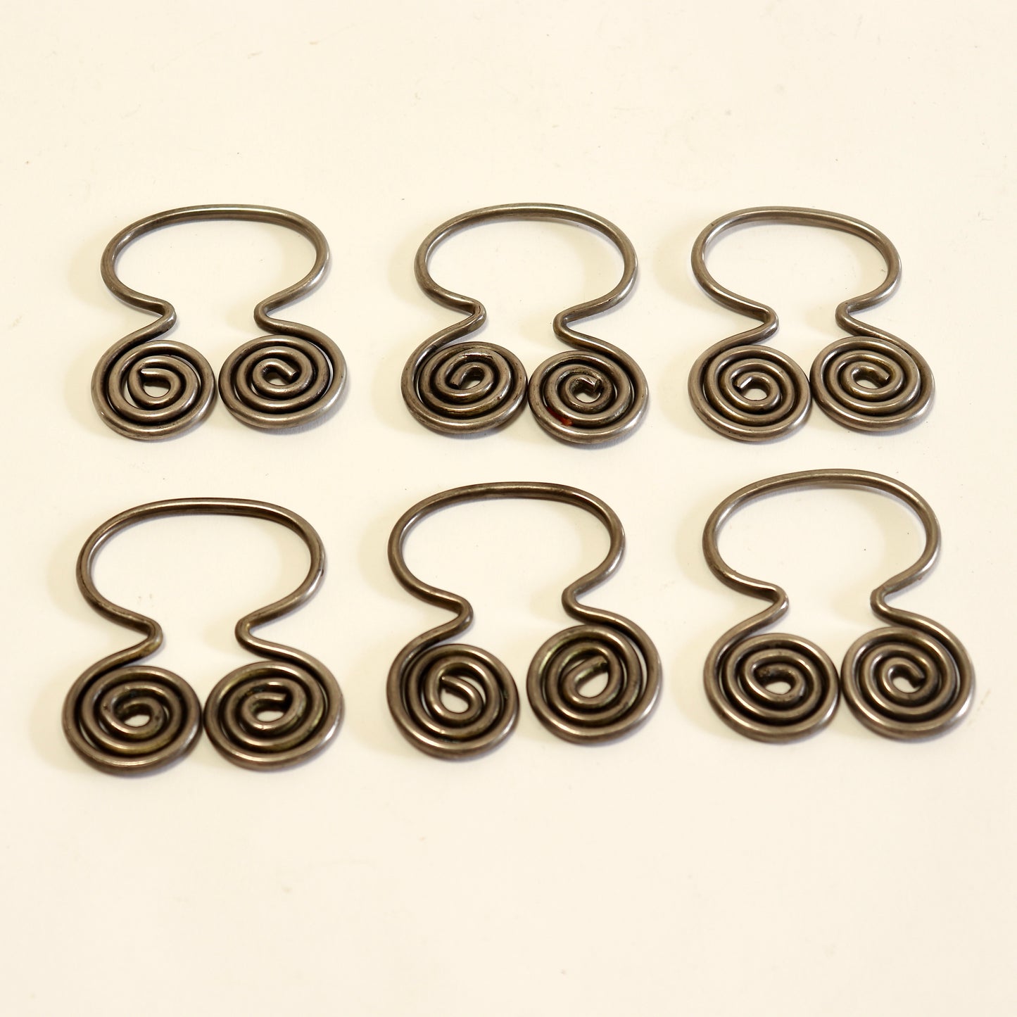 Set of six decorative spiral napkin holders.