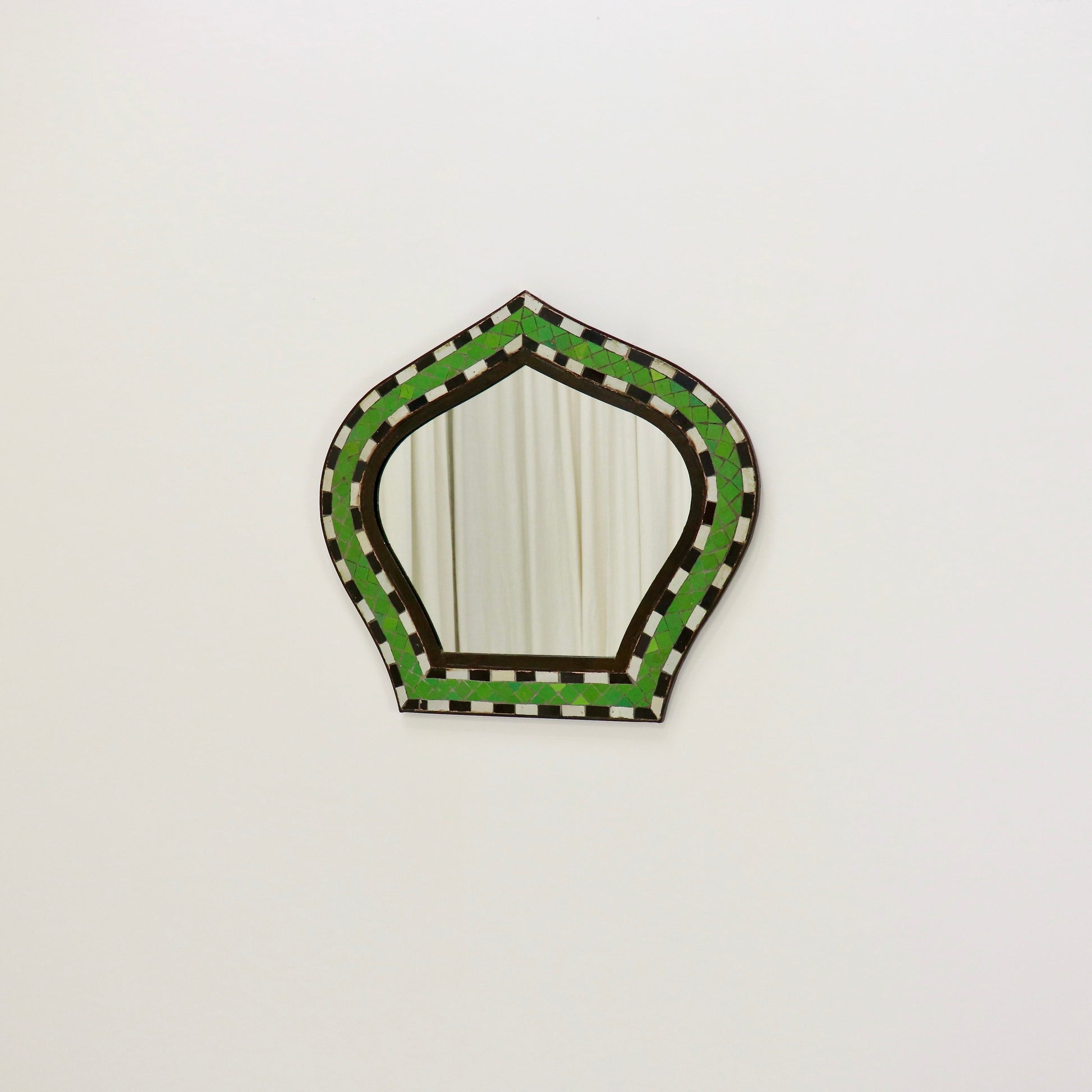 Mosaic mirror reflecting neutral interior backdrop