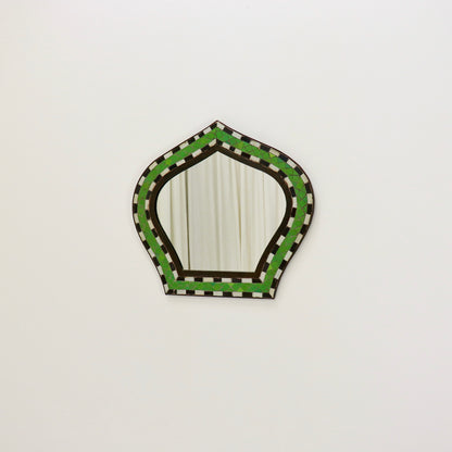 Mosaic mirror reflecting neutral interior backdrop