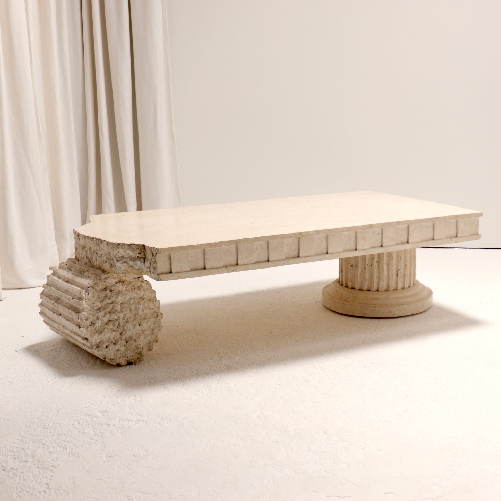 Postmodern coffee table with fractured and fluted column bases in Mactan stone, 1980s