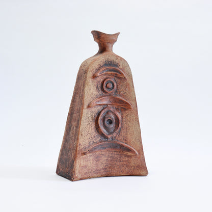 Mid-century Cornish pottery vessel with a tapered body, flared neck and raised abstract decoration in earthy brown and ochre tones.