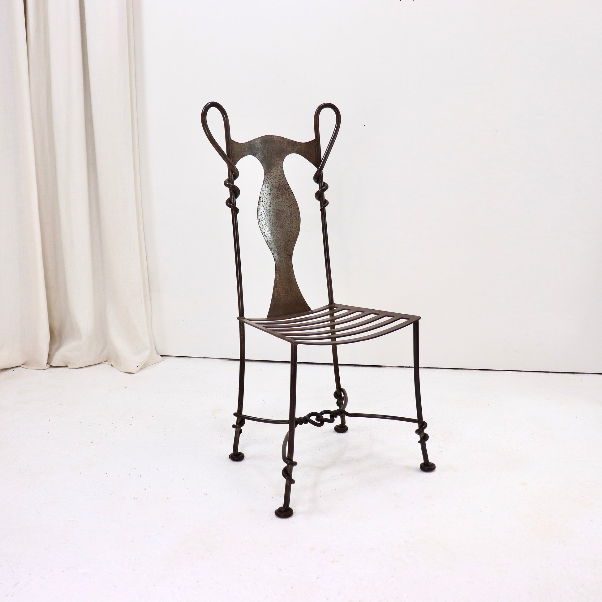 Hand-forged wrought iron chair with sculptural backrest