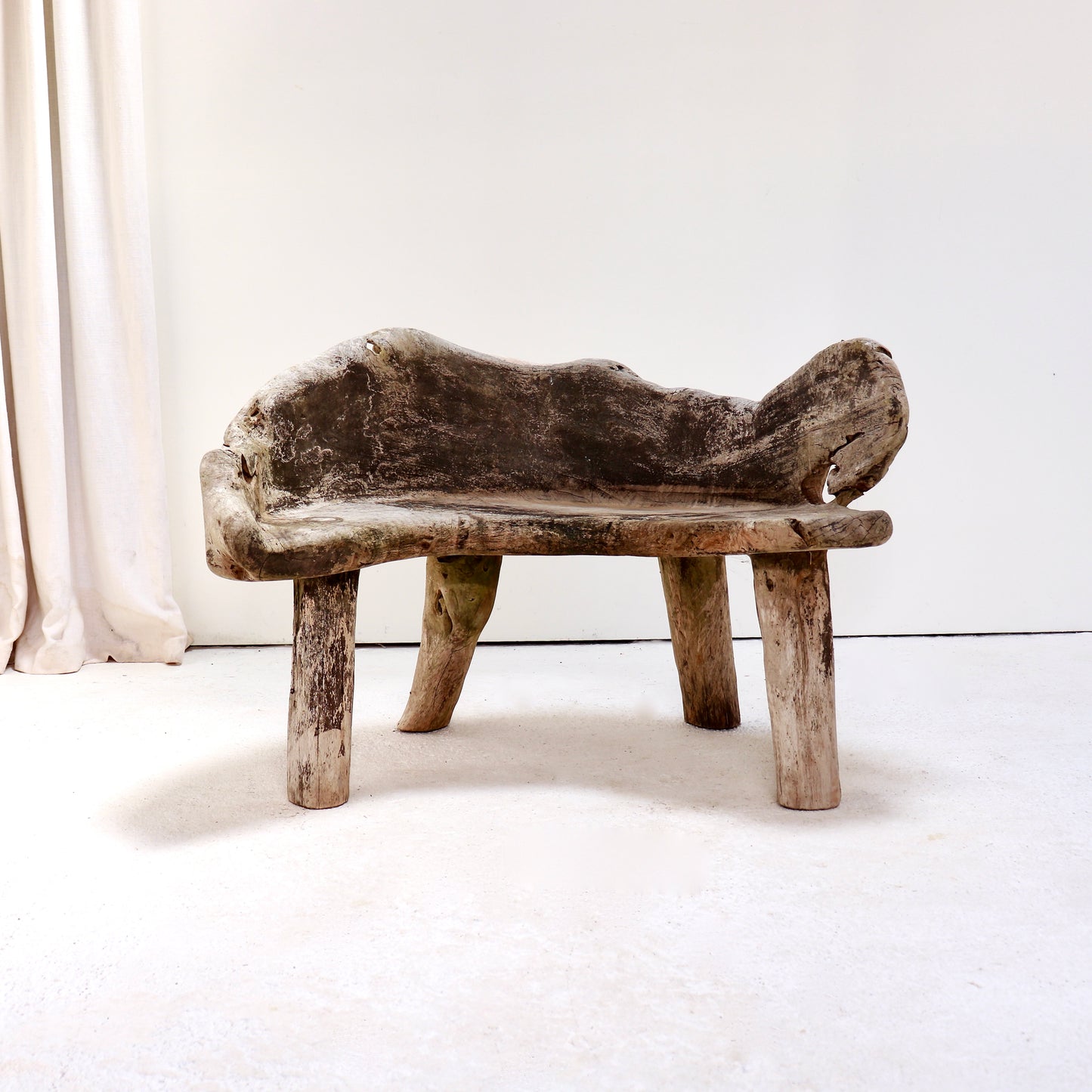 Primitive hand-carved hardwood garden bench with weathered silver-grey patina.