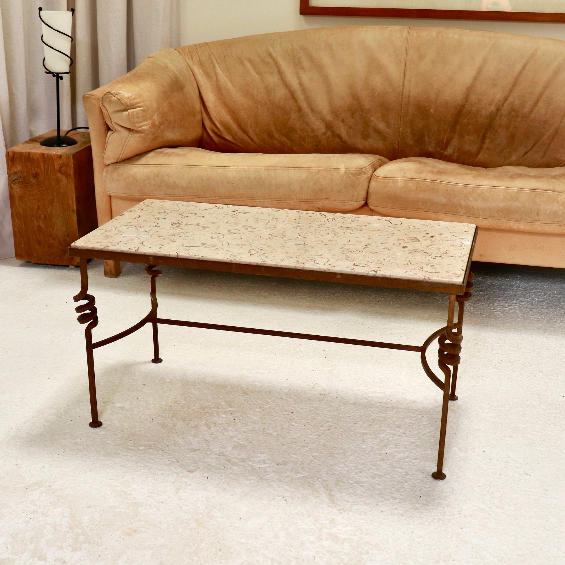 “Fossilised stone and wrought-iron coffee table, front view”