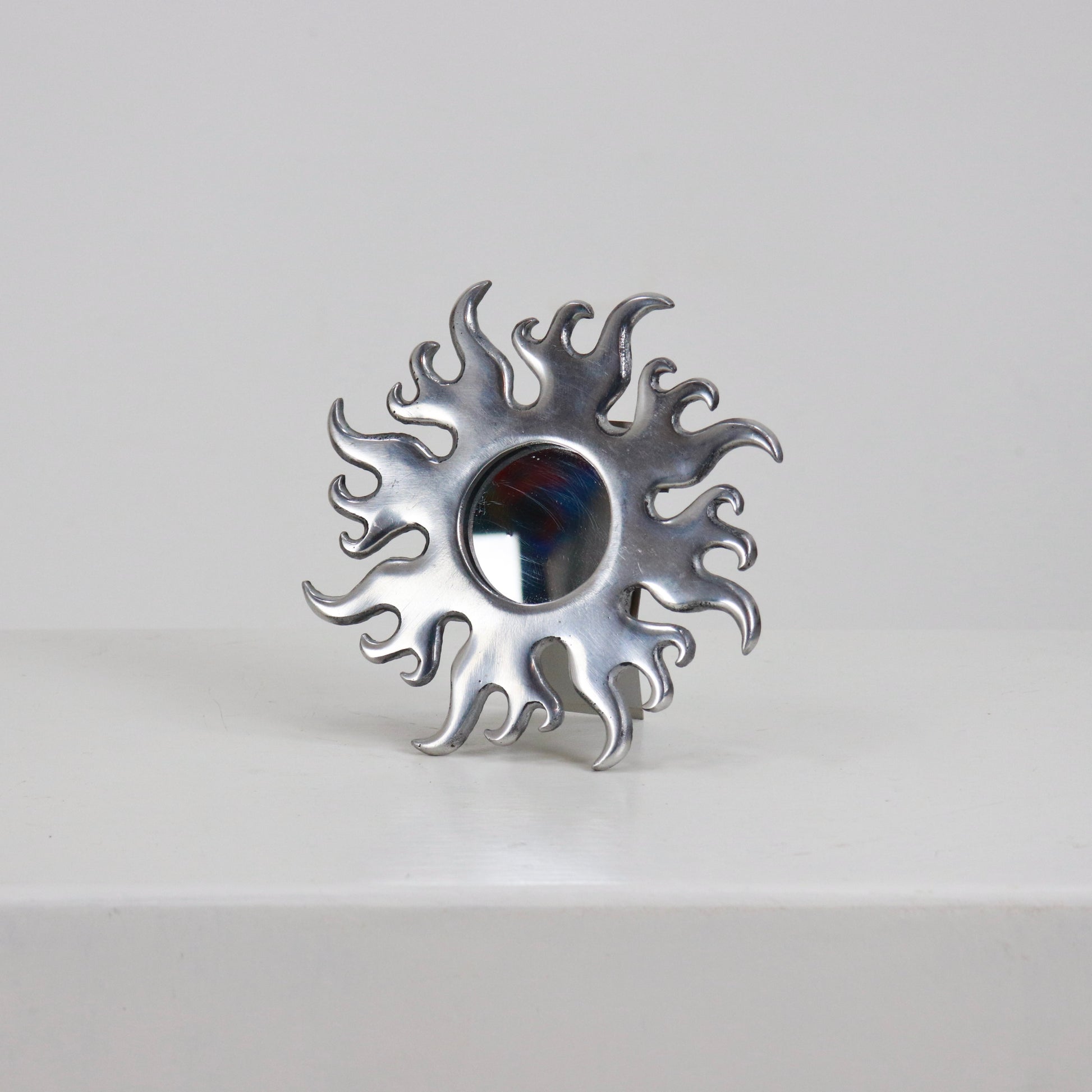 Petite cast aluminium sunburst mirror with flame rays front view