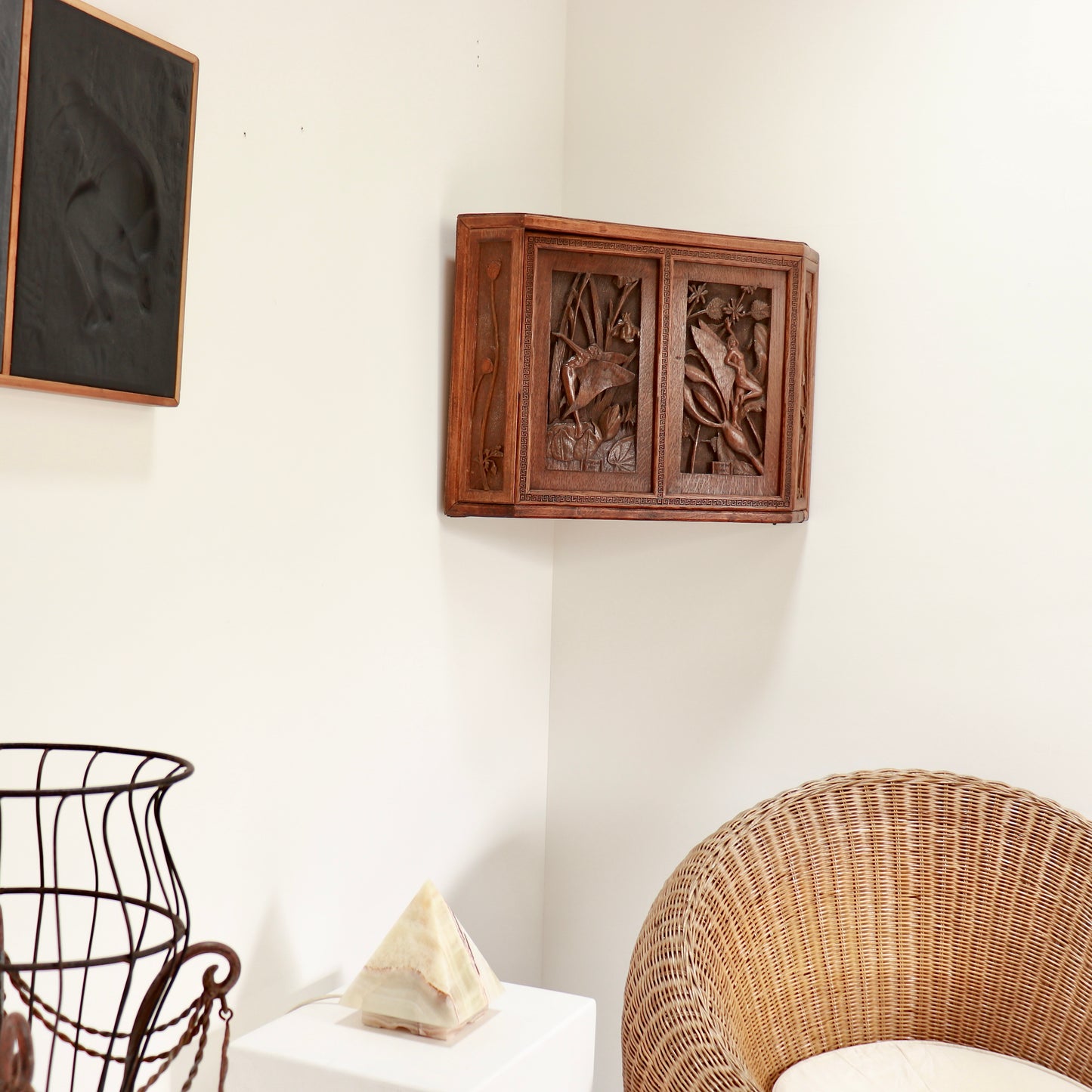 Sculptural folk art cupboard in corner interior setting