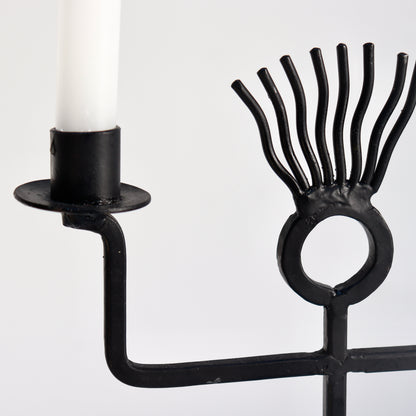 Close-up of iron rod figure candle holder arms and head