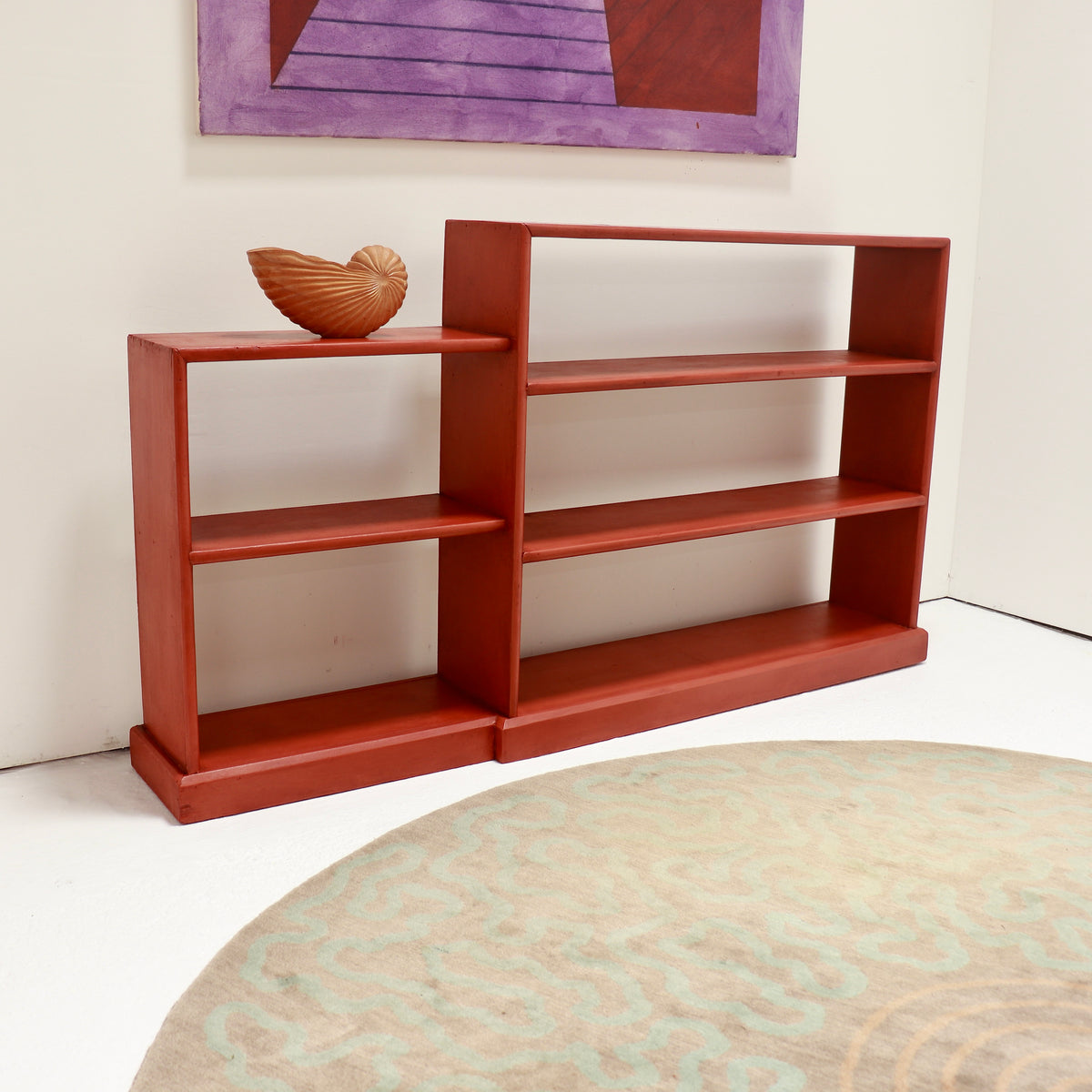 Rustic red painted wooden bookcase with asymmetrical stepped sections