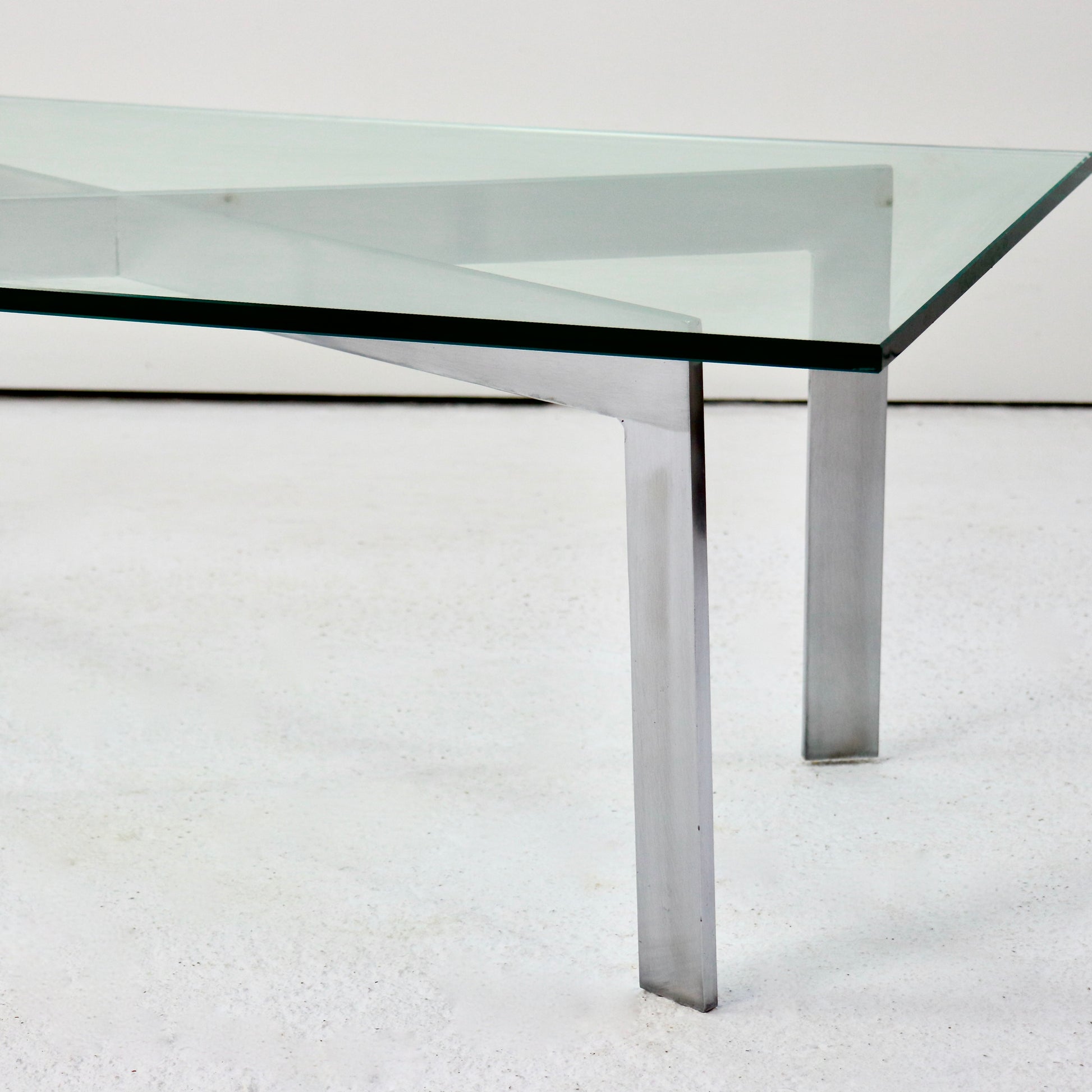 Side view of Barcelona-inspired glass and steel table