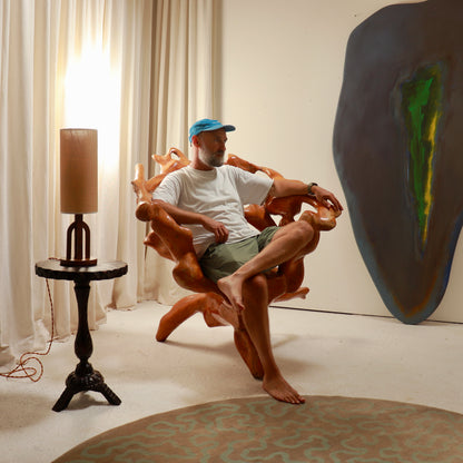 Large sculptural root wood armchair shown in an interior setting

