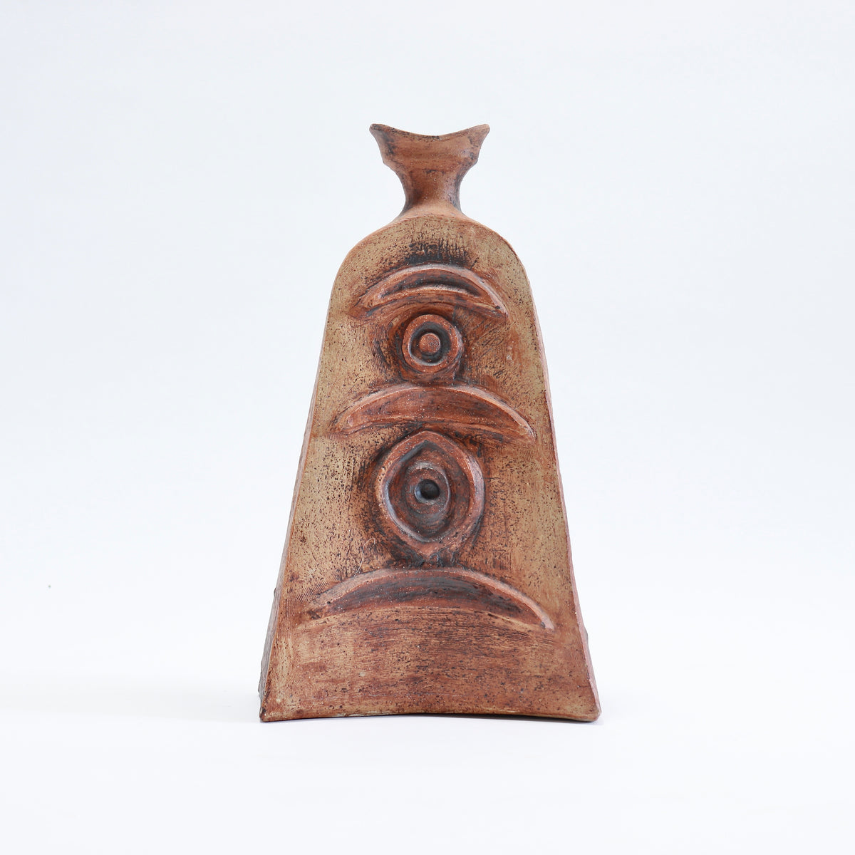 Front view of a sculptural Cornish pottery vessel with crescent shapes, concentric circles and an oval motif arranged vertically.