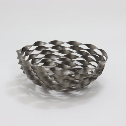 Sculptural twisted metal fruit bowl with interwoven ribbon lattice design