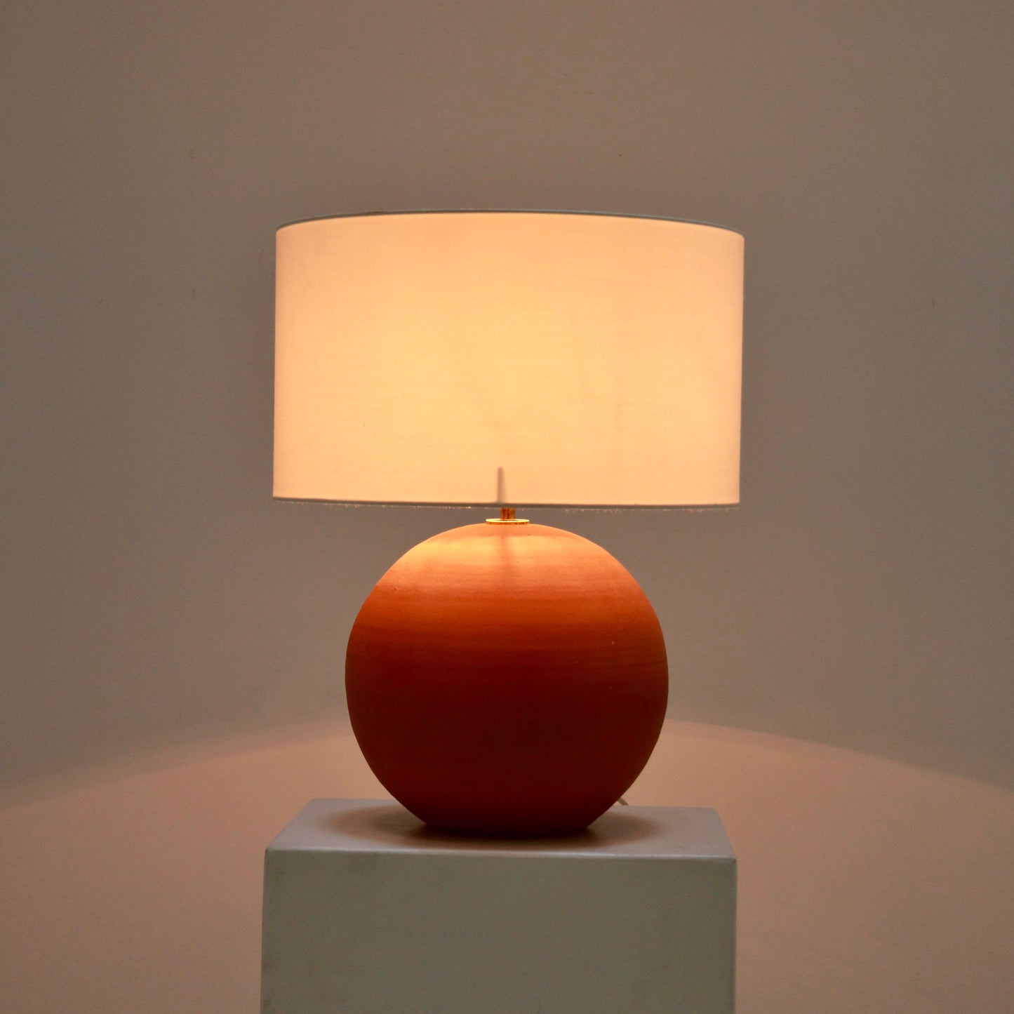 Terracotta lamp lit with soft warm glow
