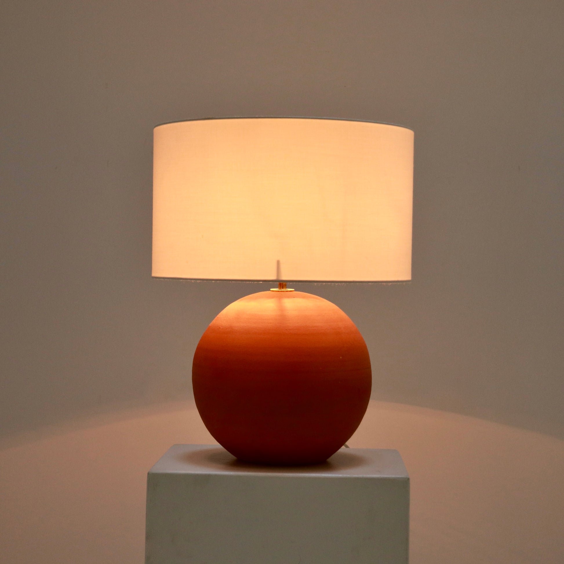 Terracotta lamp lit with soft warm glow