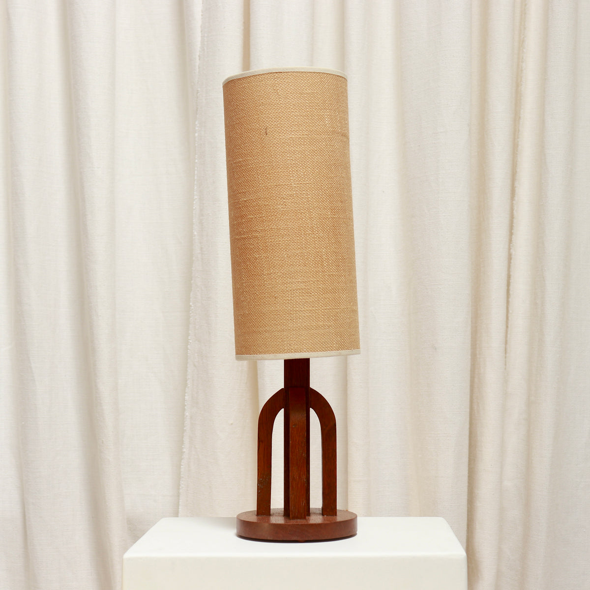 Petite oak table lamp with twin arched supports and cylindrical shade