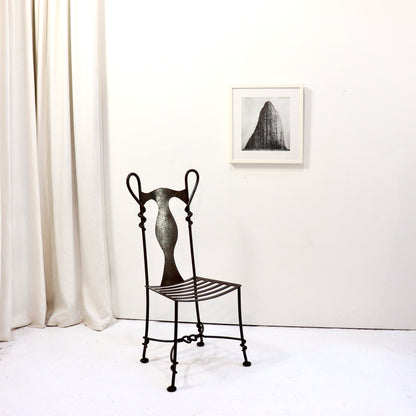 Installation view with wrought iron chair and artwork