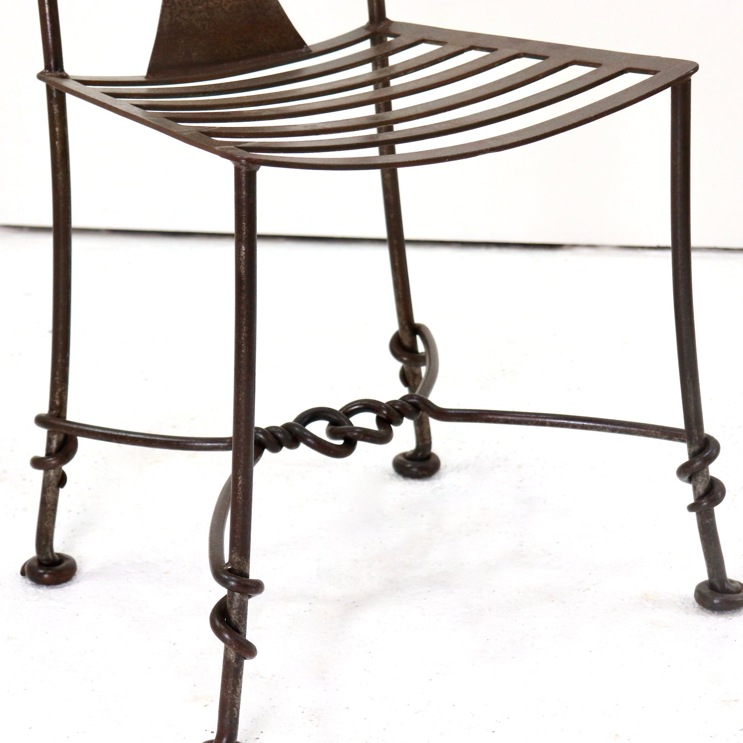 Patinated wrought iron chair legs and stretchers
