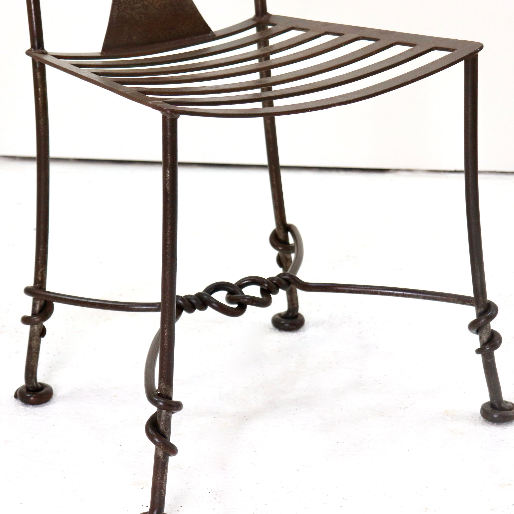 Patinated wrought iron chair legs and stretchers