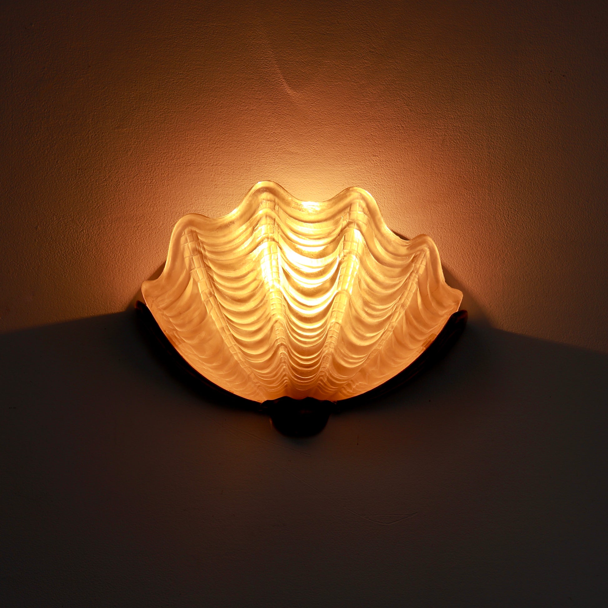 Art Deco shell sconce illuminated on wall