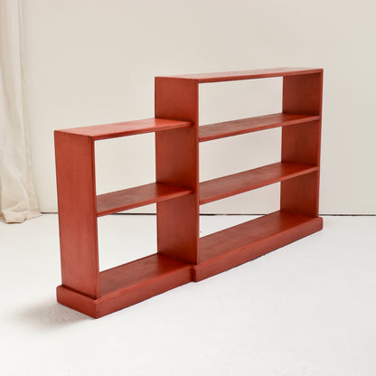 Angled view showing the shallow shelves and substantial painted plinths