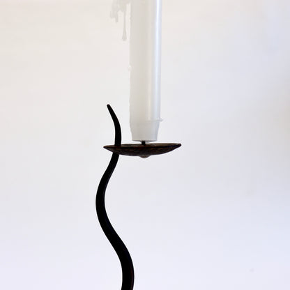 Close-up of the iron candle dish with central pricket, old wax residue and tapered stem tip.