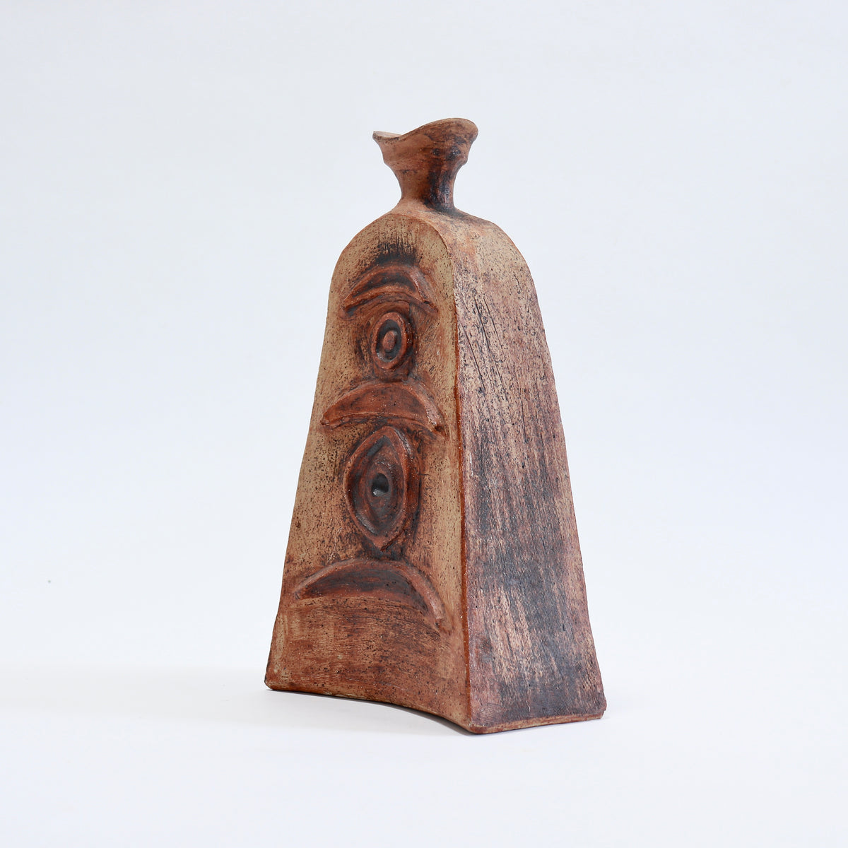 Angled view of an unattributed Cornish pottery vessel showing its flattened body, angular sides and textured brown surface.