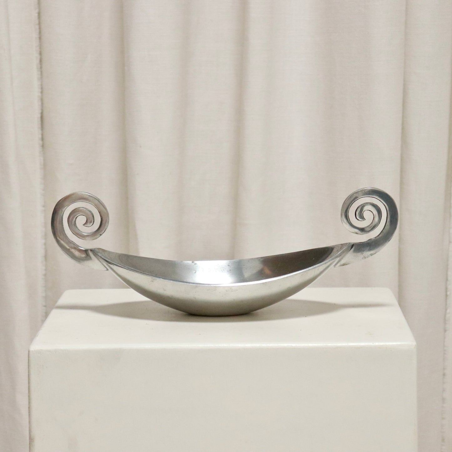 Vintage cast aluminium dish with scroll handles on a plinth.