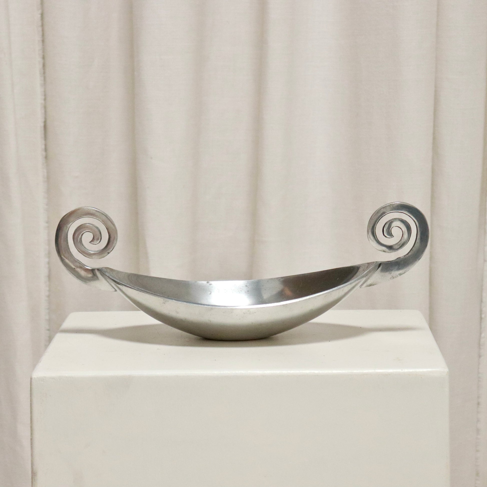 Vintage cast aluminium dish with scroll handles on a plinth.