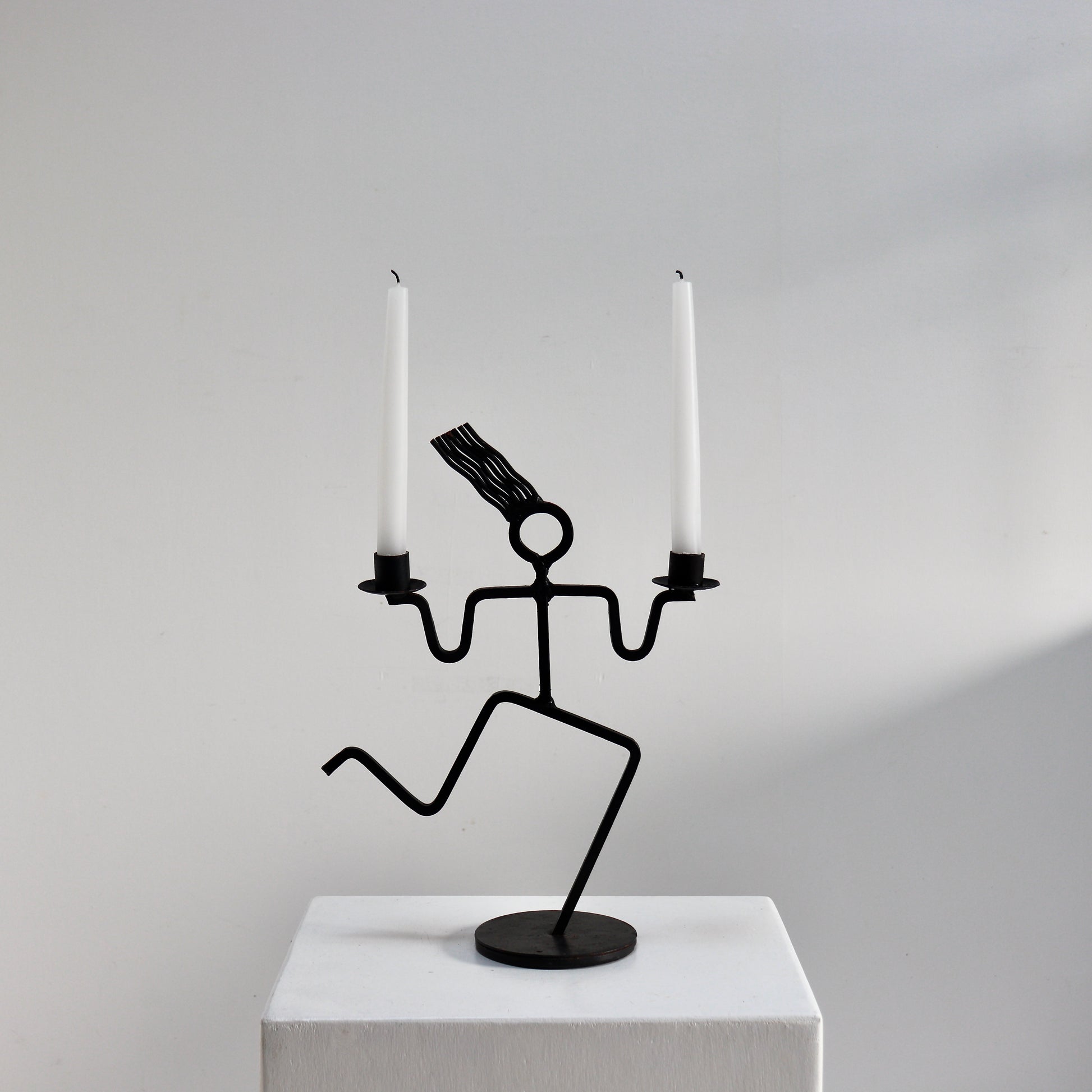 Figural iron candle holder with running figure form