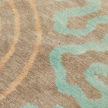 Close-up of the short wool pile with aqua squiggles, peach lines and small surface marks.
