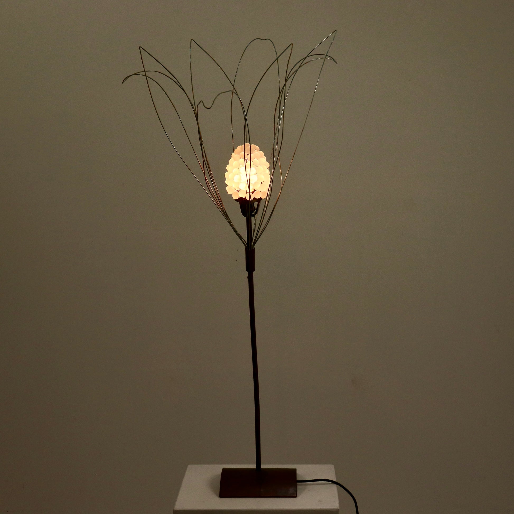 Full height view of copper and wirework sculptural lamp