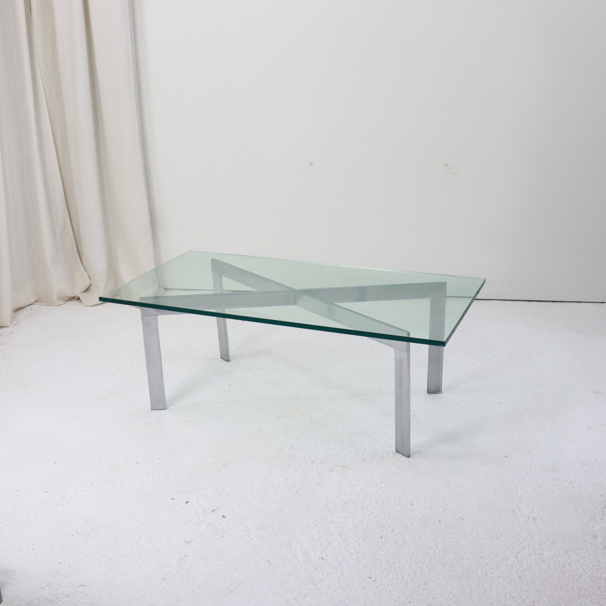 Modernist glass and nickel coffee table with X-frame base