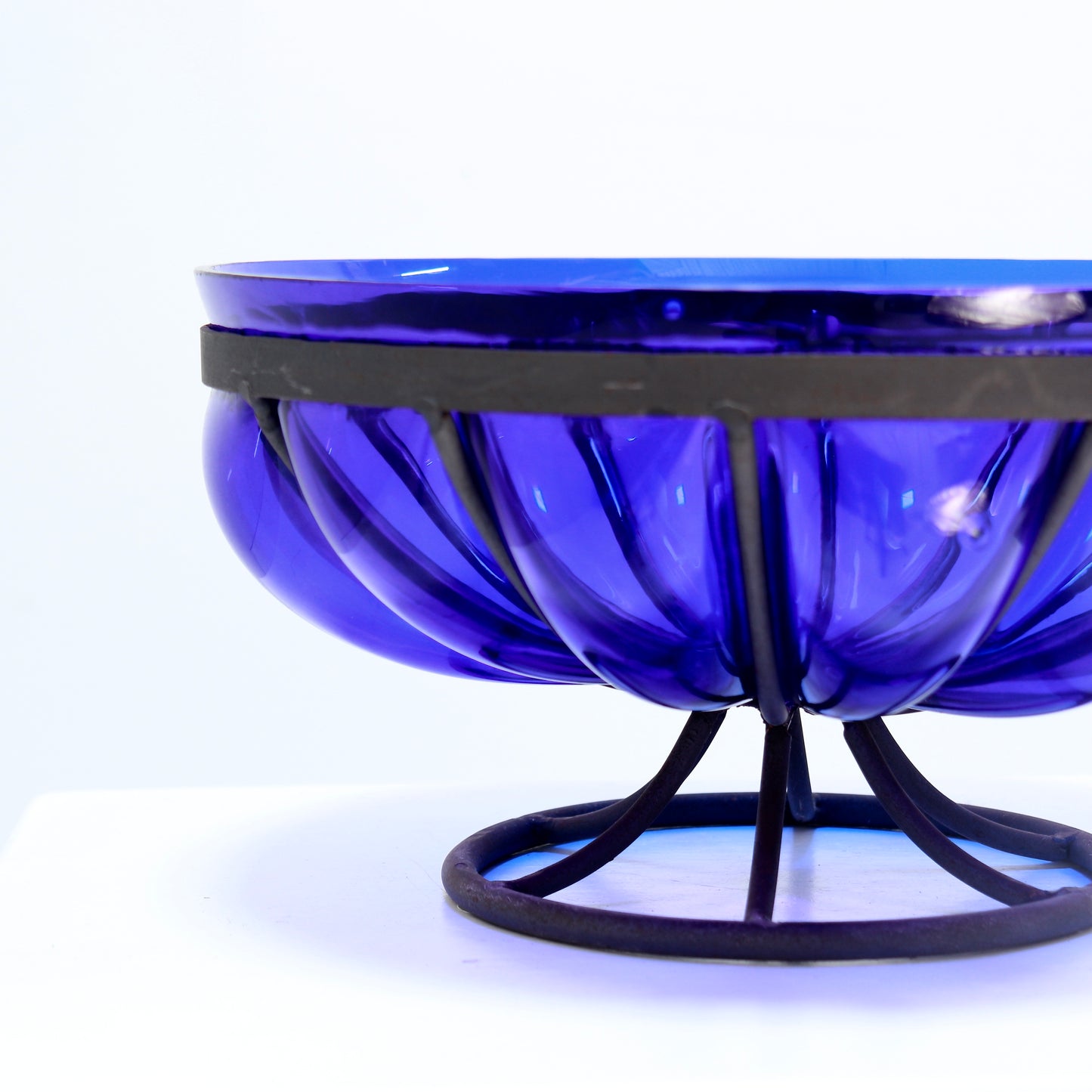 Sculptural blue glass bowl on metal base