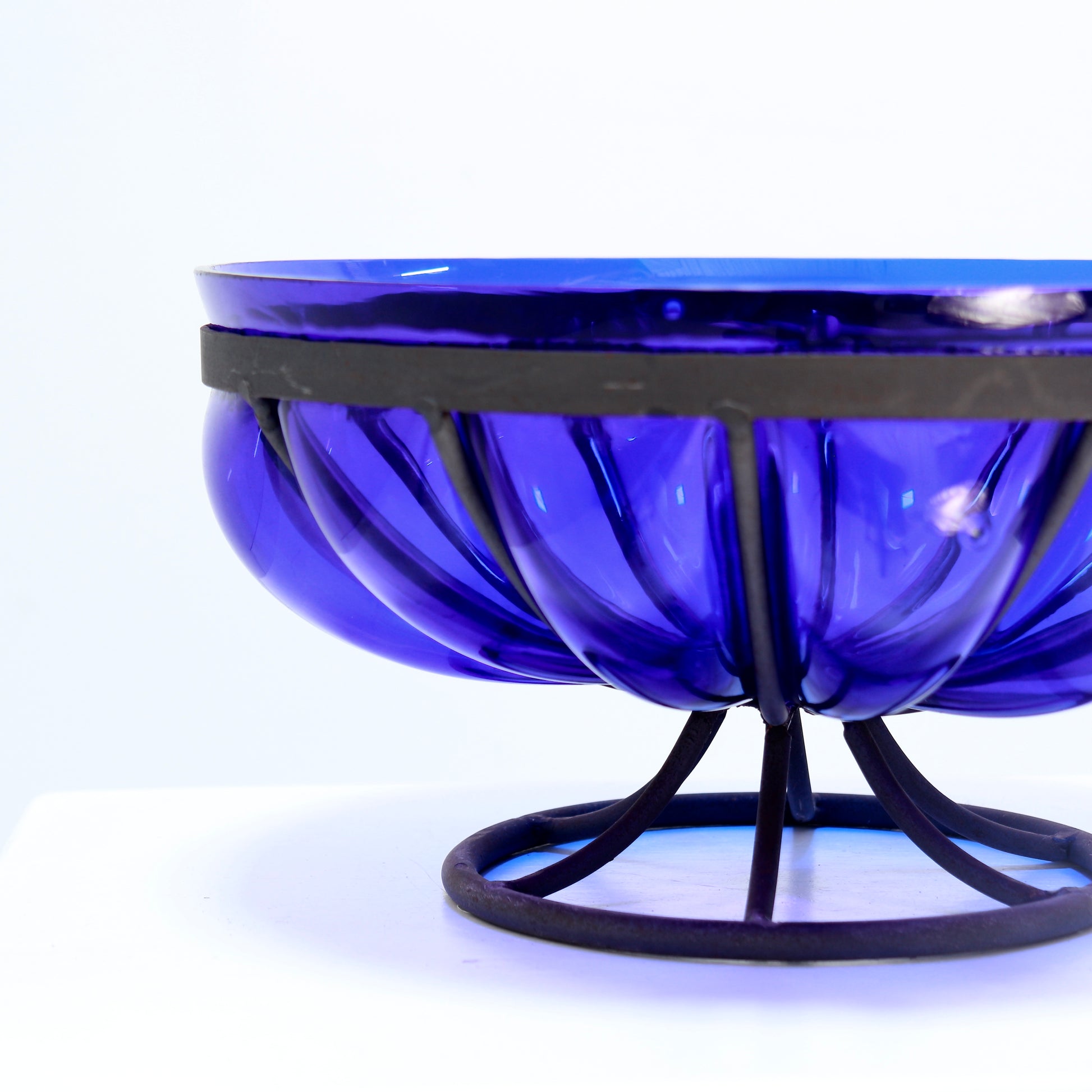 Sculptural blue glass bowl on metal base