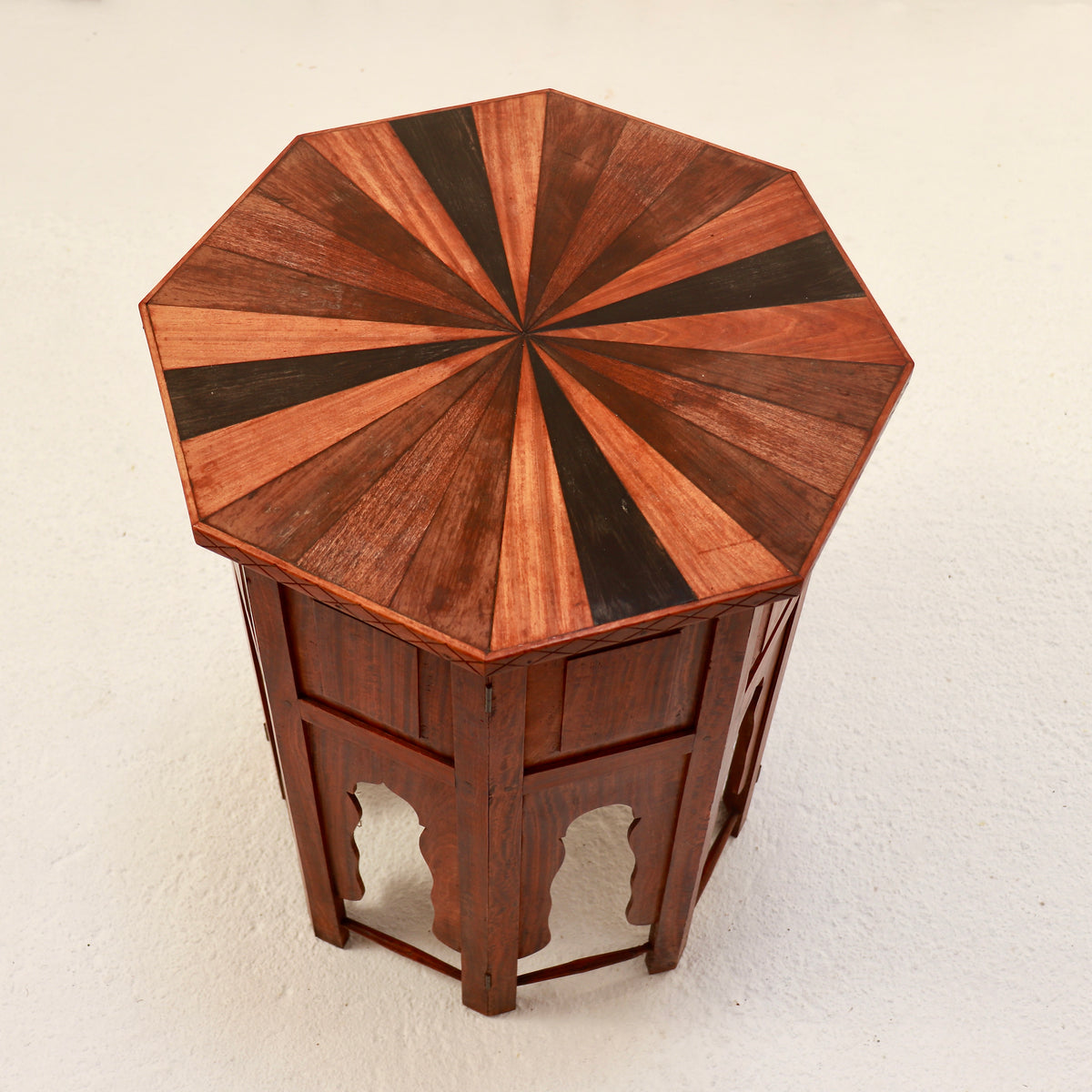 View from above showing contrasting specimen woods arranged in a sunburst across the octagonal tabletop.
