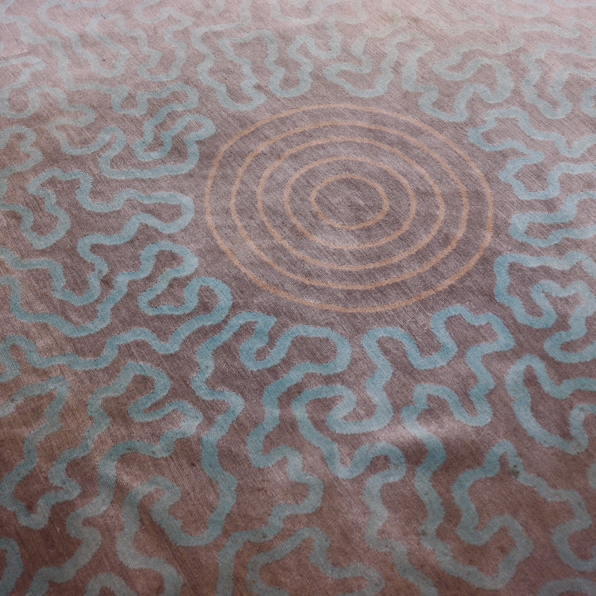 Close view of the concentric peach rings surrounded by pale aqua abstract lines.
