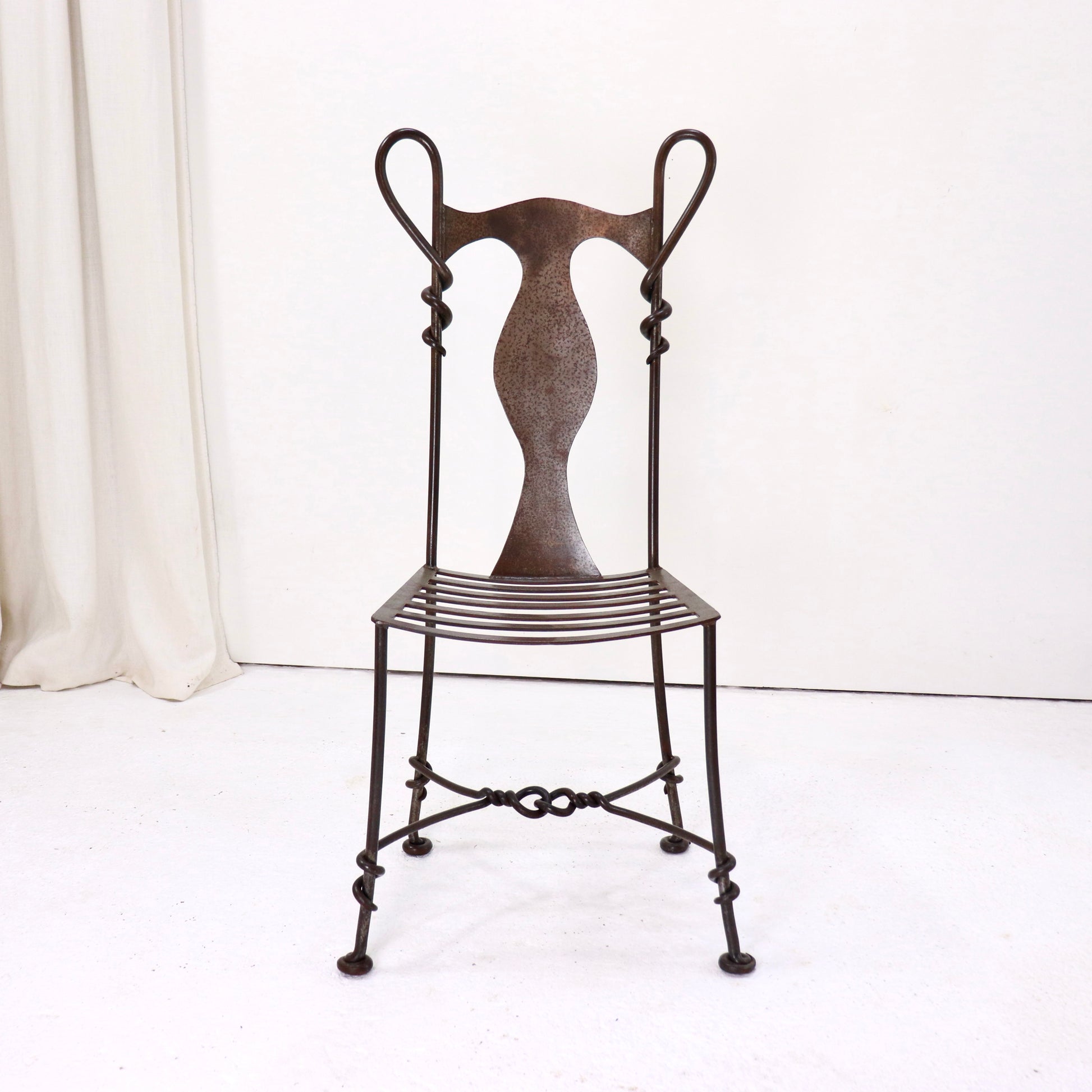 Artisan-made wrought iron chair, front view