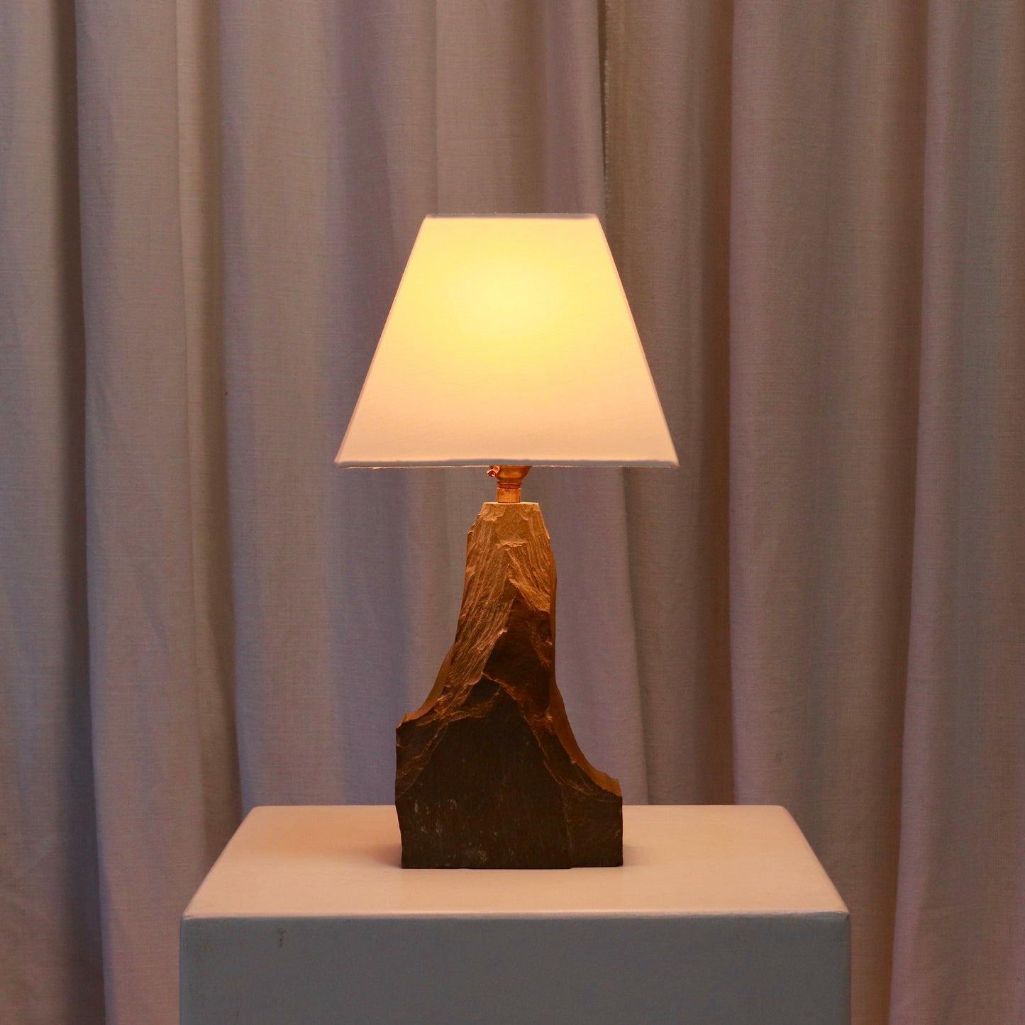 Mid-century slate lamp lit with warm ambient glow