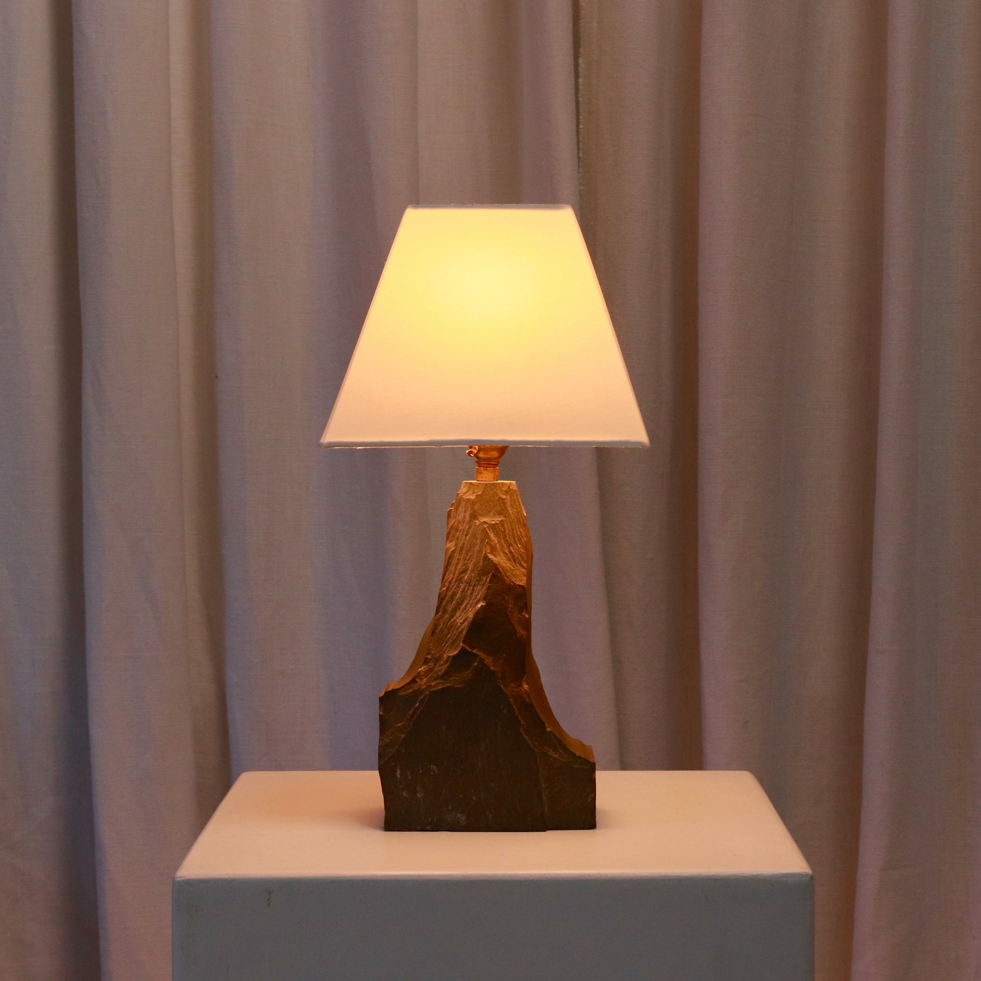 Mid-century slate lamp lit with warm ambient glow