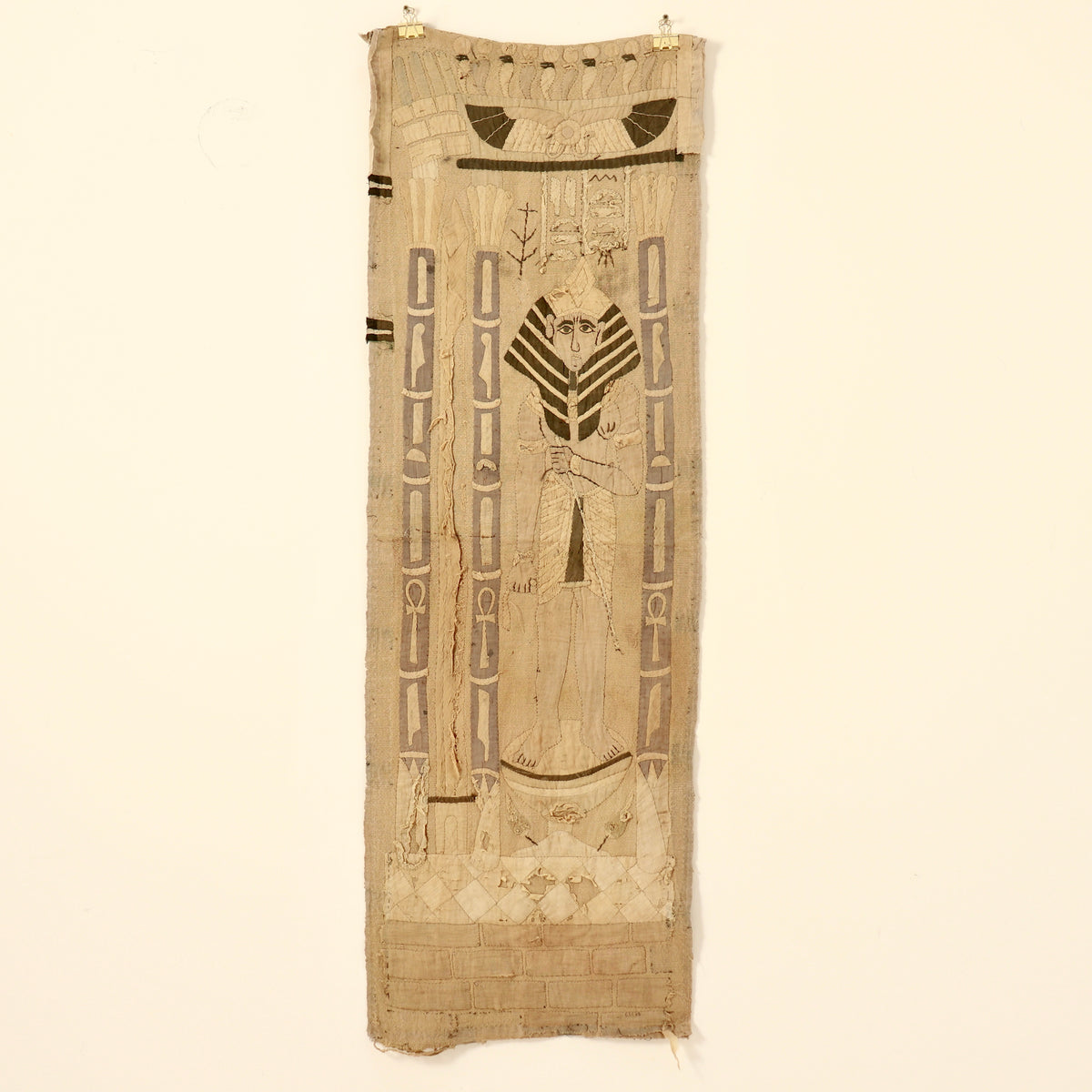 Long Egyptian Revival appliqué wall hanging displayed on a pale wall