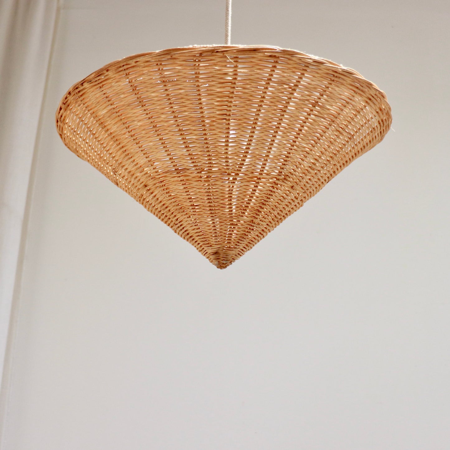 Single vintage rattan cone pendant light photographed from below