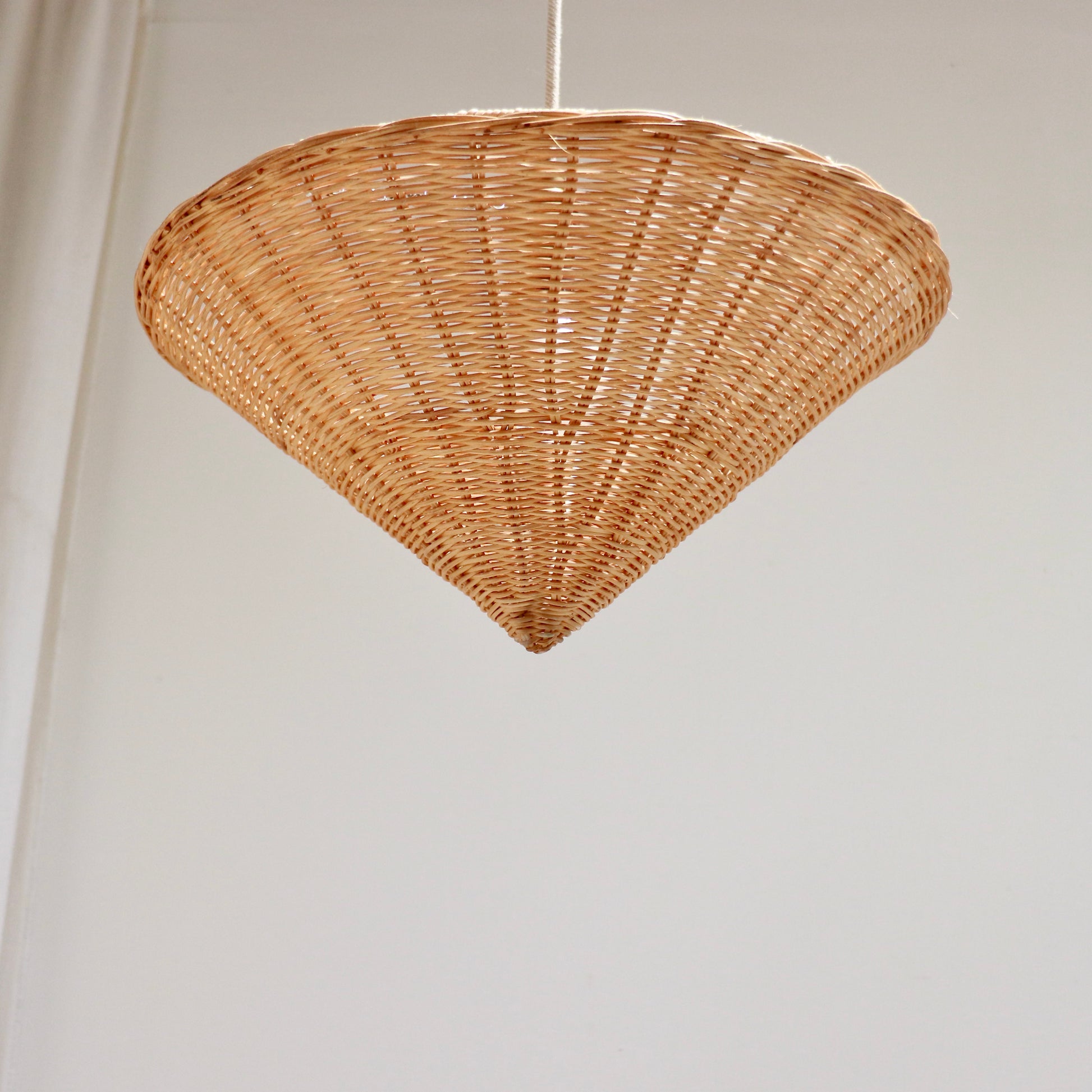 Single vintage rattan cone pendant light photographed from below
