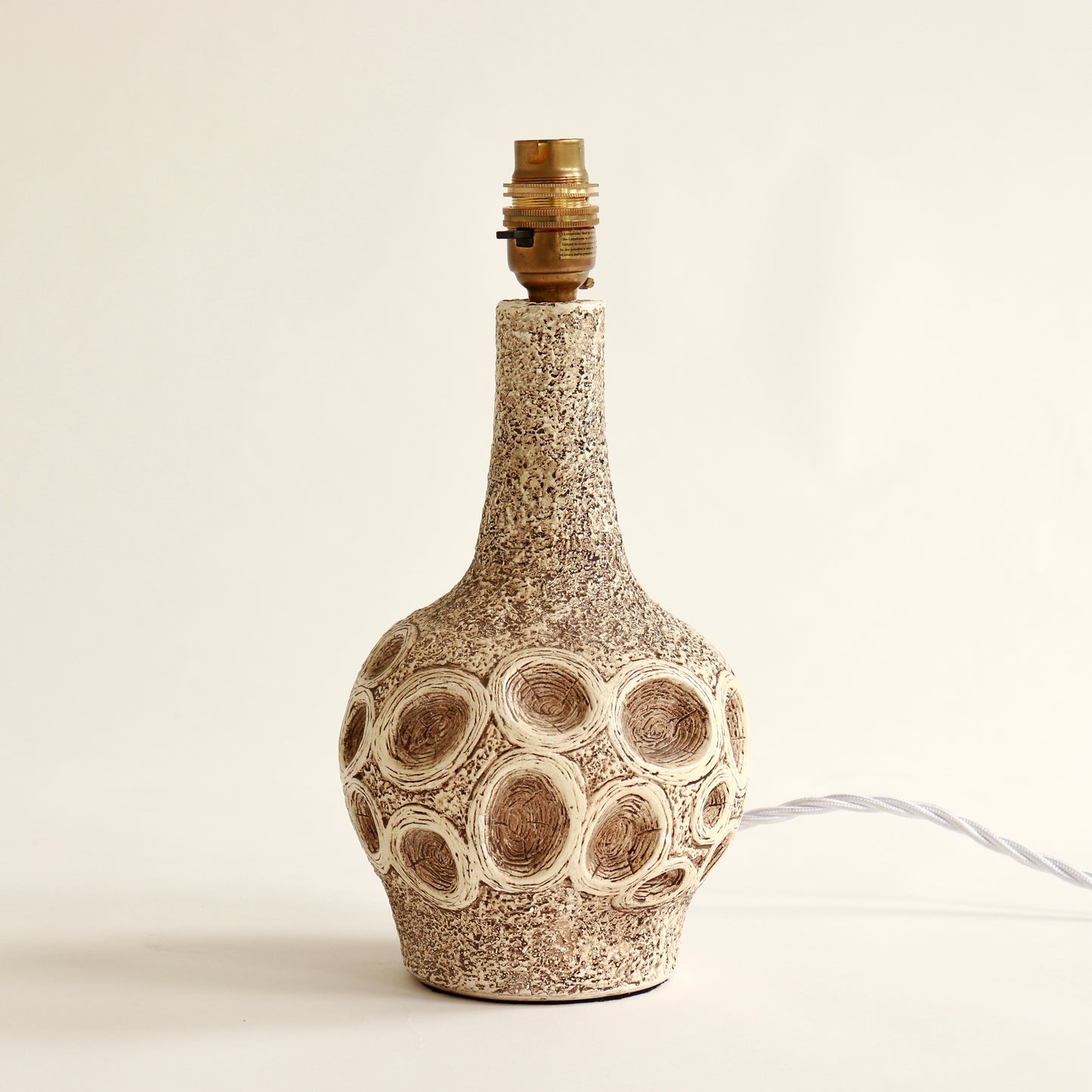 Sculptural chalkware lamp base with circular motif detail
