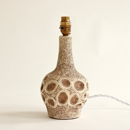 Sculptural chalkware lamp base with circular motif detail
