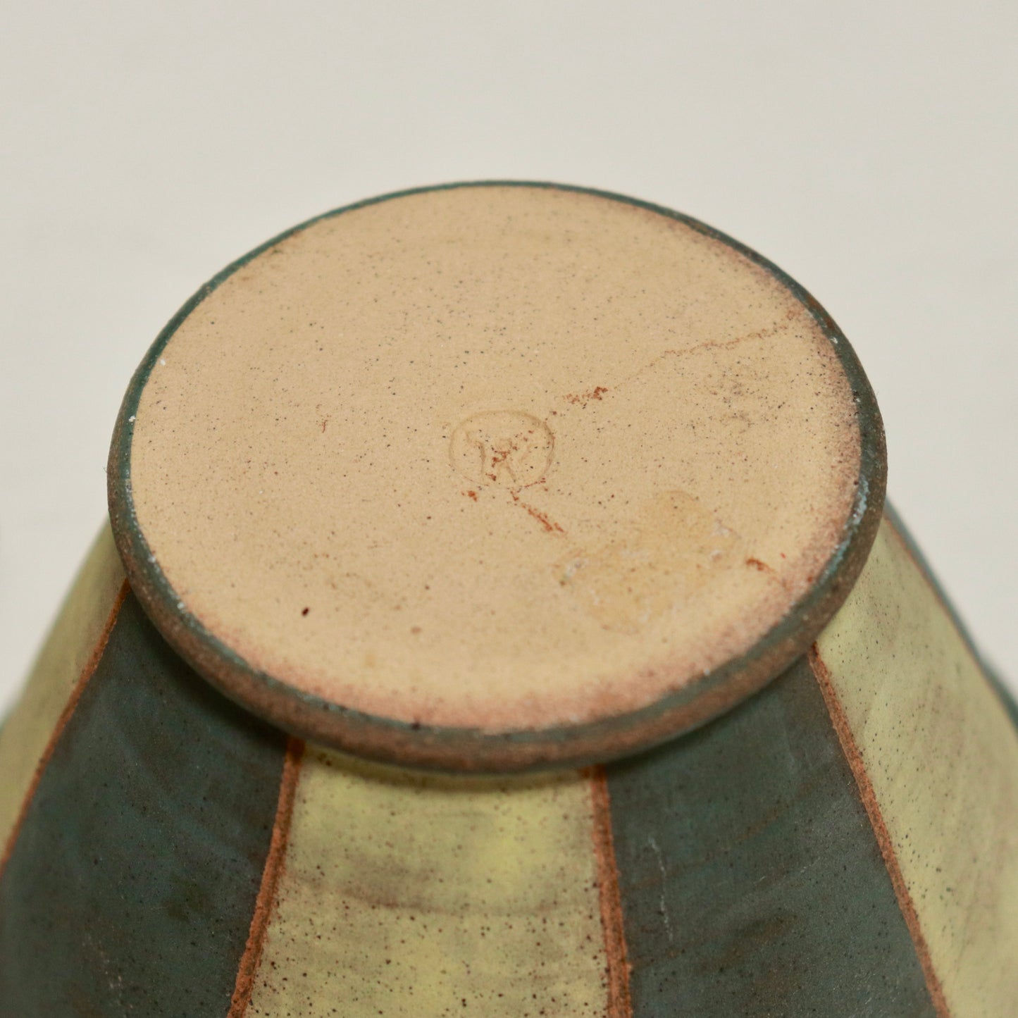 Potter’s impressed mark on the base of the striped lidded pot.
