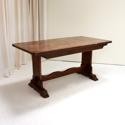 Three-quarter view of 19th-century oak refectory table with trestle bases.