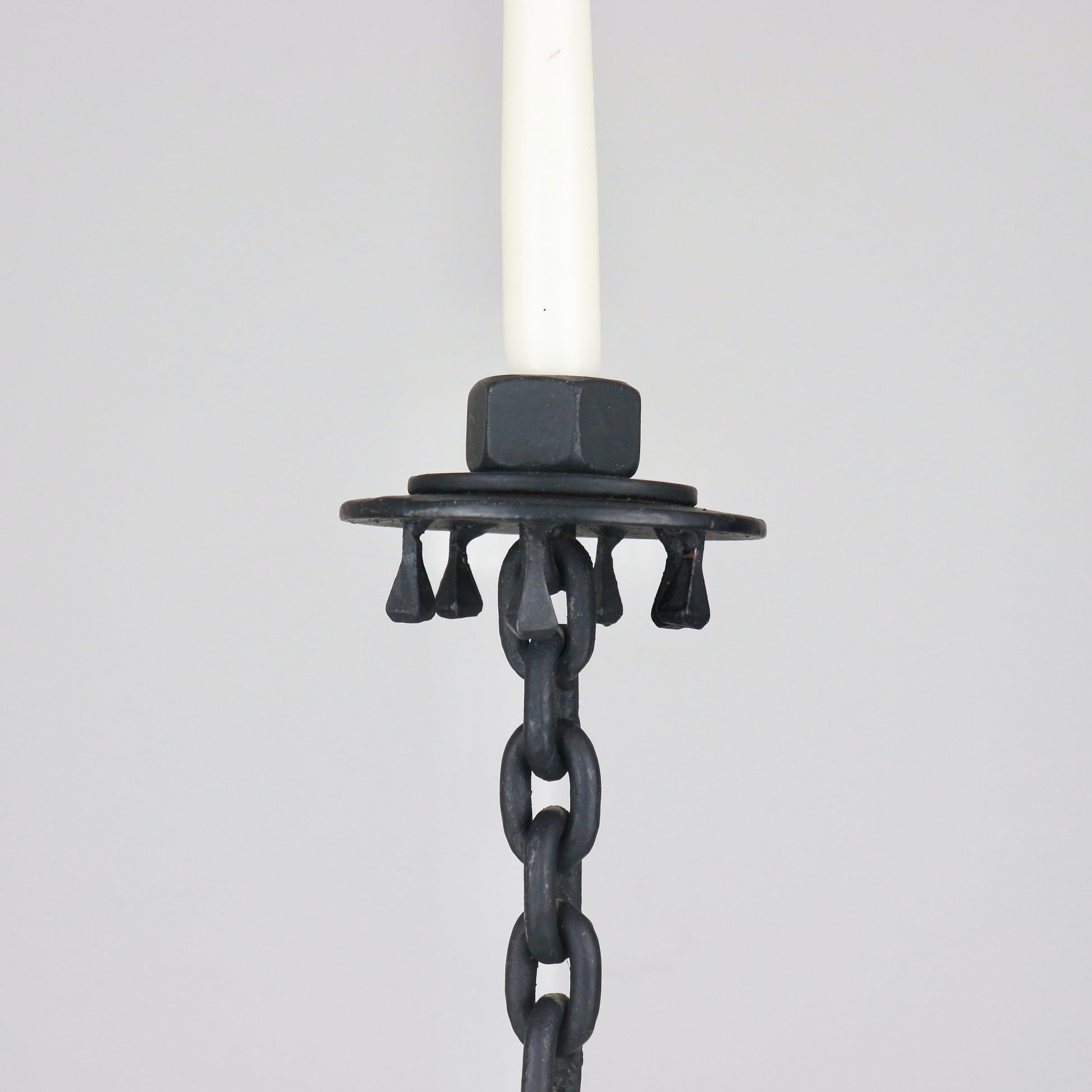 Vintage iron candlestick with horseshoe-style base and dark patina