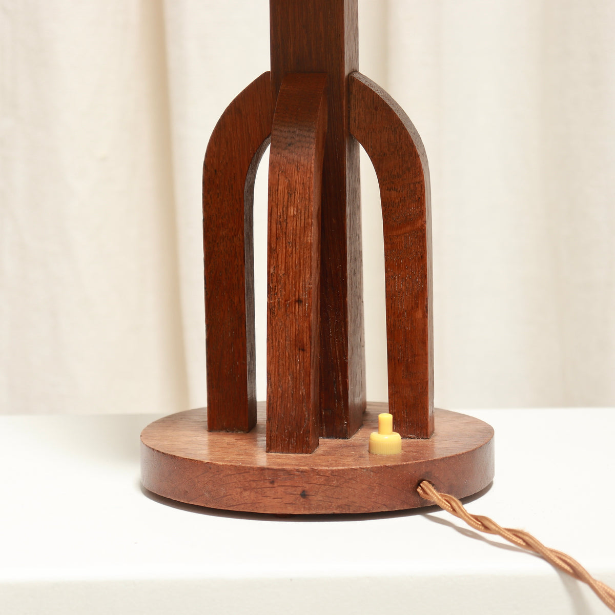 Close-up of the oak lamp’s open arches and square central stem